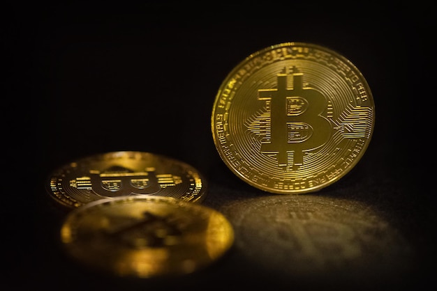 Gouden bitcoin symbolische munten op zwarte achtergrond