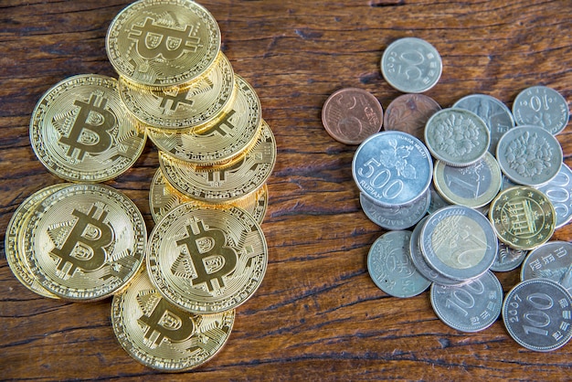 Gouden bitcoinmuntstuk en geld op houten lijst.