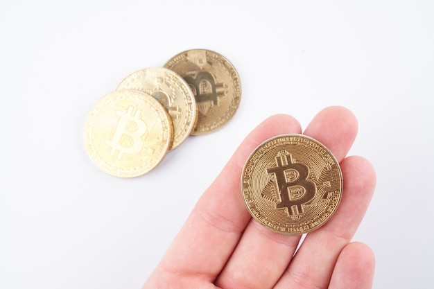 Gouden bitcoins in de palm van de hand geïsoleerd op een witte achtergrond close-up met kopie ruimte