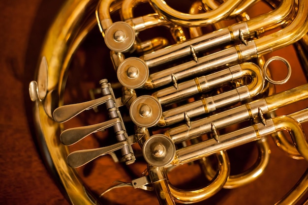 gouden blaasinstrument Franse hoorn op een houten achtergrond Gouden Franse hoorn