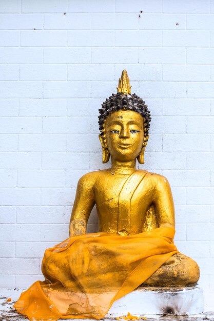 Foto gouden boeddha op een witte bakstenen blok