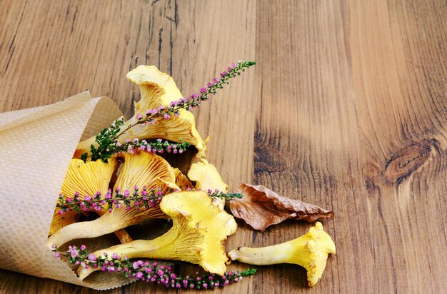 Foto gouden chanterelle en bloem op houten tafel