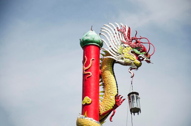 Gouden Chinese draak gewikkeld rond rode paal bij Wat Muang-tempel in Ang Thong Thailand