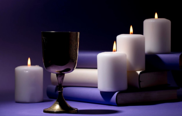 Foto gouden christelijke kelk met kaarsen en paarse achtergrond