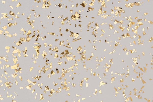 Gouden confetti op grijze achtergrond, feest goudfolie glitter achtergrond.