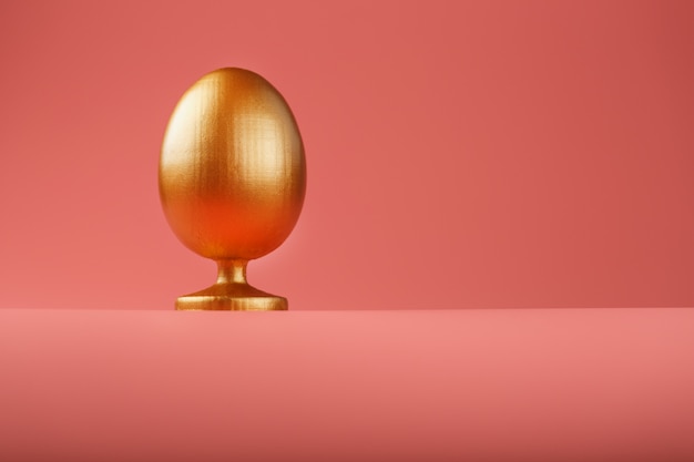 Gouden ei met een minimalistisch concept. Ruimte voor tekst. Easter egg ontwerpsjablonen. Stijlvol decor met minimaal concept.