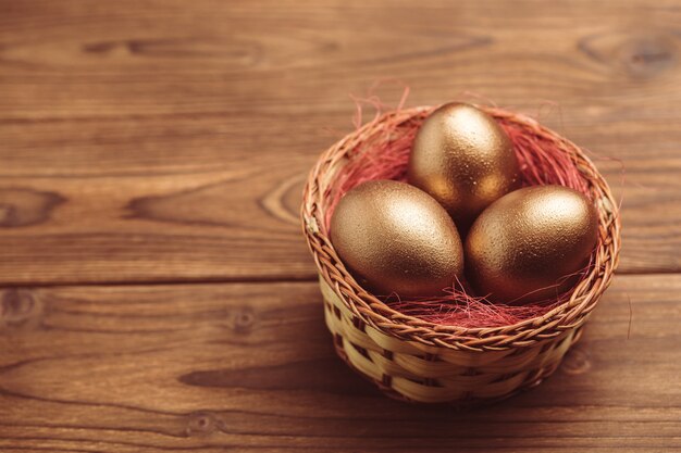 Gouden eieren op houten tafel