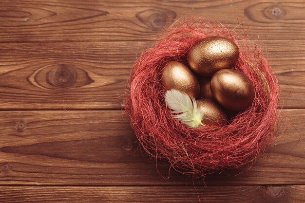 Gouden eieren op houten tafel