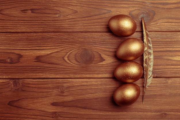 Gouden eieren op houten tafel