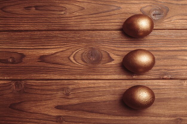 Gouden eieren op houten tafel