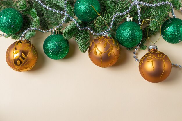 Gouden en groene kerstballen met dennentakken en zilveren pareldecoratie. Plat leggen met kopie ruimte
