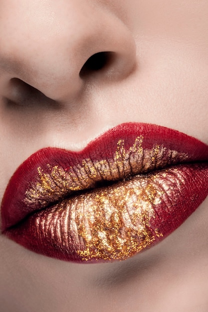 Foto gouden en rode lippenstift in mode make-up in close-up foto