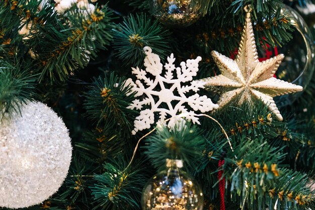 Gouden en witte kerstballen met glitters op een kerstboom close-up