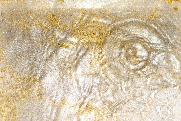 Gouden en zilveren schittert in het water. Glitter en vloeibare textuur. Abstracte achtergrond met gouden en zilveren deeltjes. Glanzende viering achtergrond. Feestelijke achtergrond voor uw projecten.