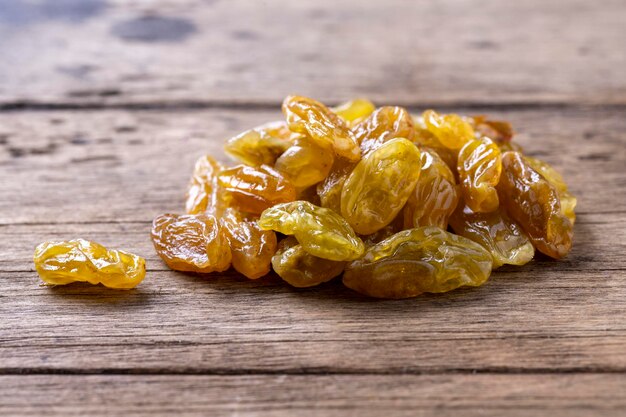 Gouden en zwarte rozijnen op houten tafel achtergrond.