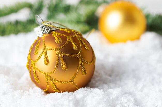 Gouden fonkelende Kerstmisbal in de sneeuw. Wenskaart met kopie ruimte
