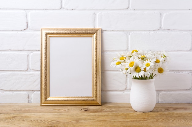 Gouden frame met kamille boeket in rustieke vaas