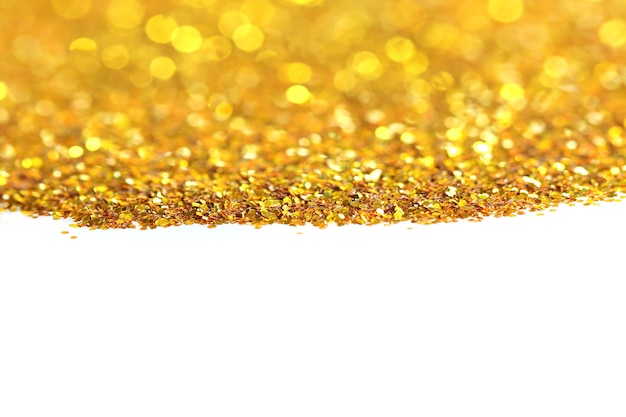 Gouden glitter zand textuur handvol verspreid op witte, abstracte achtergrond met kopie ruimte.