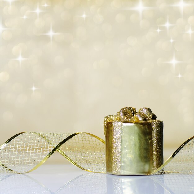 Gouden kerst lint ornament op achtergrond van intreepupil gouden lichten. Ondiepe DOF.