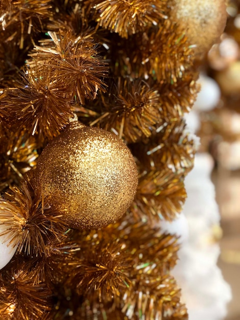 Gouden kerstbal op kerstboom decoratie vakantie achtergrond