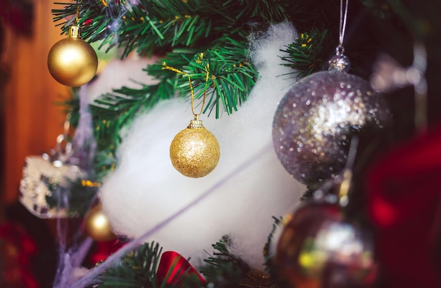 Gouden kerstballen en rode ballen met rode linten sieren op kerstboom Kerst achtergrond