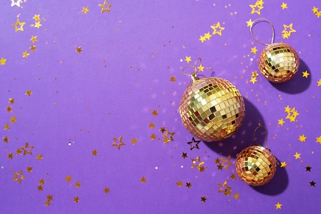 gouden kerstballen met glanzende sterren op paarse achtergrond