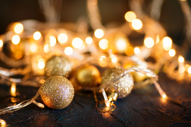 Gouden kerstballen tegen onscherpe lichten.