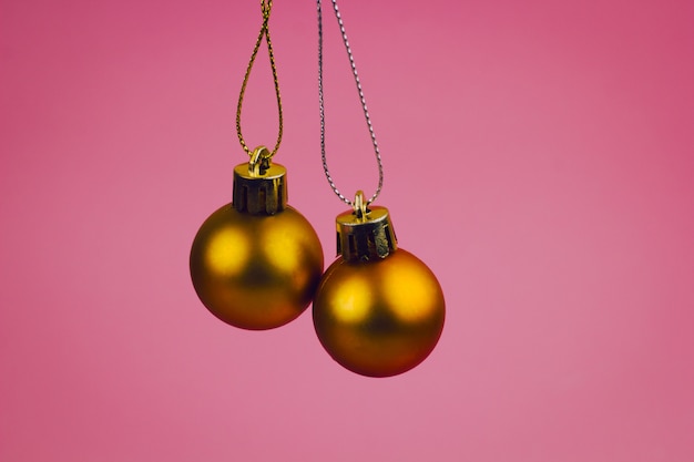 Gouden Kerstmisballen op een heldere roze achtergrond