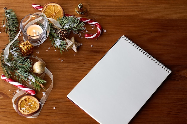 Gouden kerstversiering, kerstmuts en een open blanco notebook