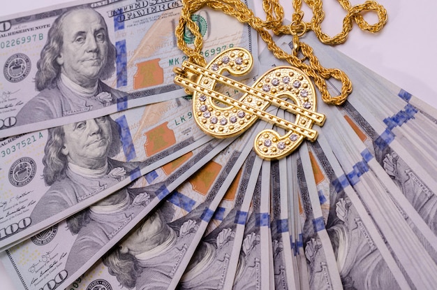 Gouden ketting met dollarteken op bankbiljetten van Amerikaanse dollars