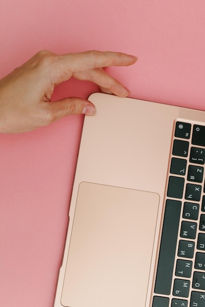 Gouden laptop op een roze achtergrond