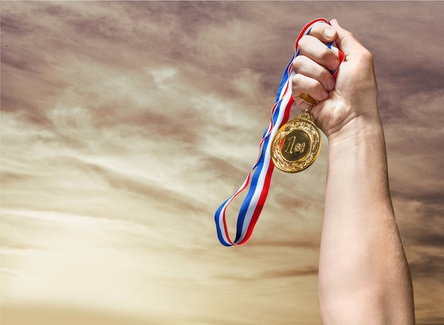 Gouden medaille met lint in de hand op achtergrond