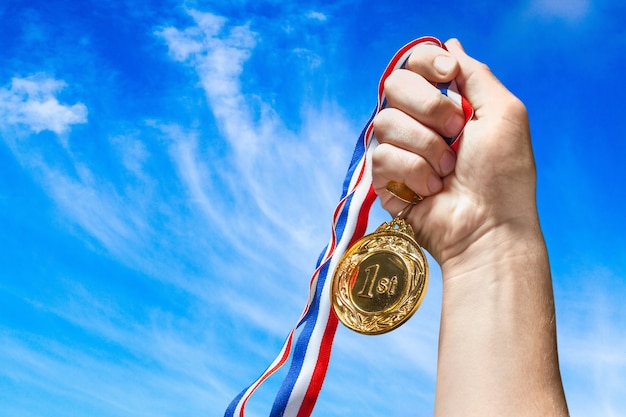 Gouden medaille met lint in de hand op achtergrond