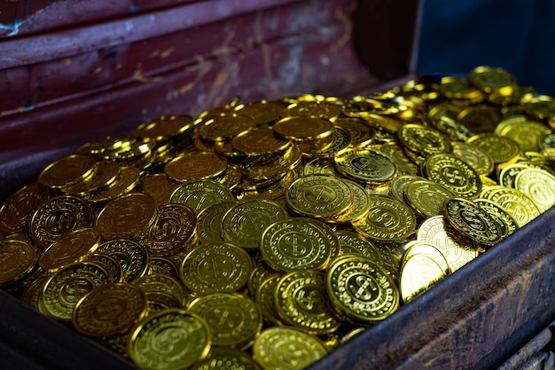 Gouden munten stapelen in schatkist op zwarte achtergrond