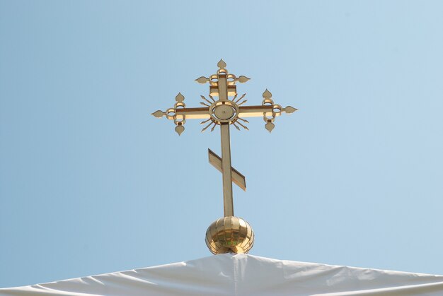 Gouden orthodox kruis met blauwe hemelachtergrond