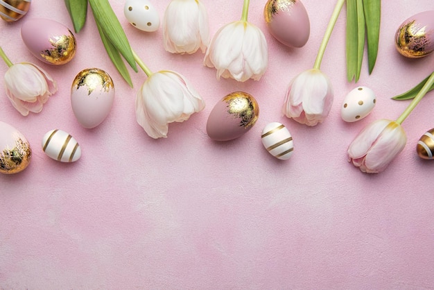 Gouden paaseieren en roze tulpen op roze achtergrond