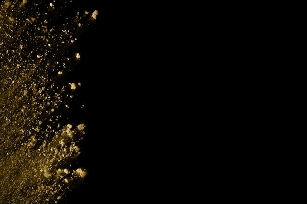 Gouden poederexplosie op zwarte achtergrond.