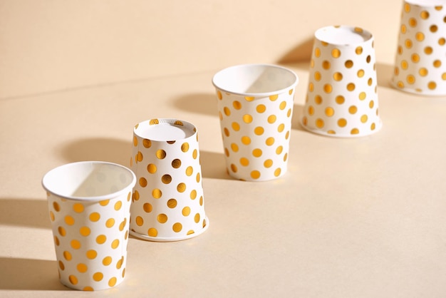 Gouden polka dot papieren beker geïsoleerd op beige background