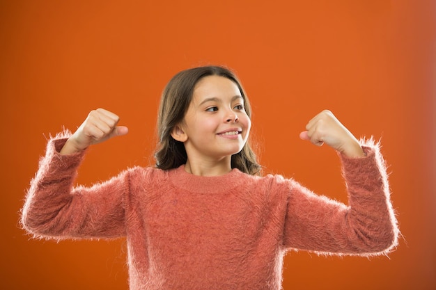 Gouden regels voor het opvoeden van mentaal sterke kinderen. Kind schattig meisje Toon biceps gebaar van kracht en kracht. Voel je zo krachtig. Meisjes regels concept. Opvoedingsadviezen voor meisjes. Sterk en krachtig.