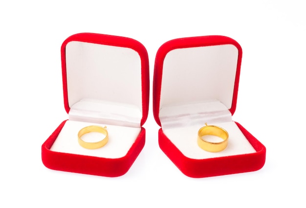 Gouden ringen op rode fluwelen doos geïsoleerd op een witte achtergrond