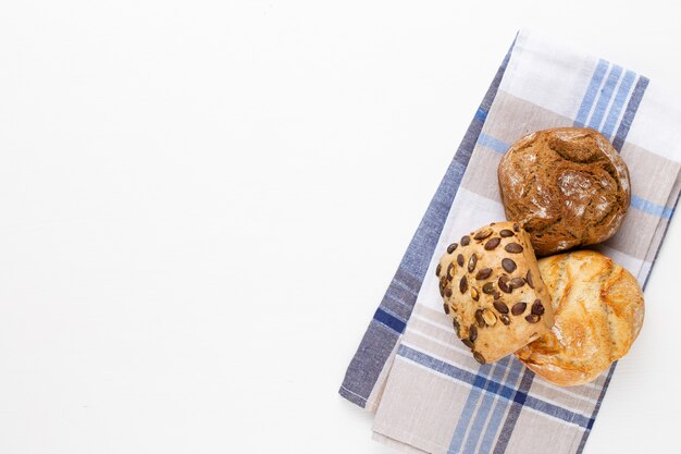 Gouden rustieke knapperige broden en broodjes op houten achtergrond. Stilleven gevangen van bovenaf gezien, plat gelegd.