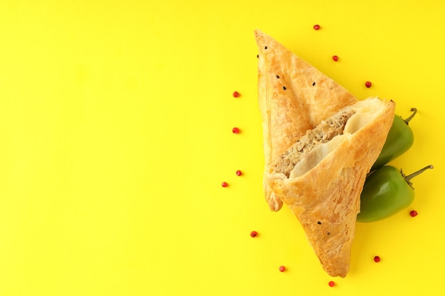 Foto gouden samsa met ingrediënten op gele achtergrond