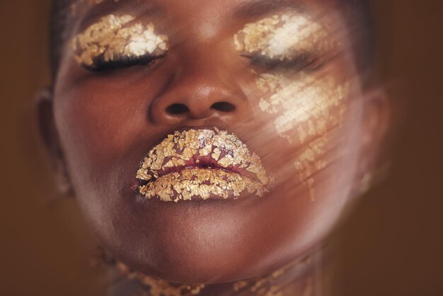 Gouden schoonheid gezicht en vrouw close-up met vervaging in studio met glitter cosmetica en sprankelende kunst Bro