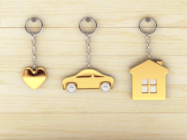 Gouden sleutelhangers in de vorm van huis, auto en hart