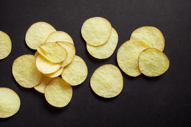 Gouden smakelijke chips met een knapperige korst op een zwarte 3d illustratie als achtergrond