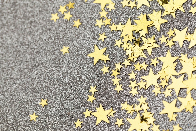 Gouden ster confetti op een zilveren glitter achtergrond feestelijke vakantie achtergrond