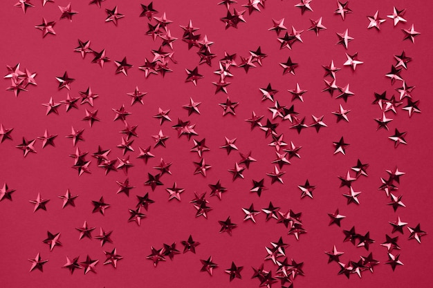 Gouden sterren glitter confetti op rode achtergrond Feestelijke vakantie achtergrond