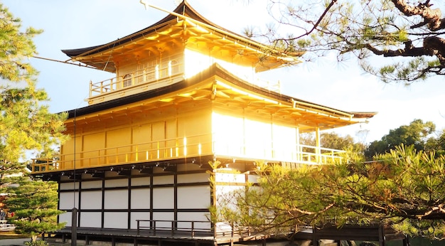 Gouden tempel of Kinkakuji in Kyoto Japan schieten vanaf de achterkant en hebben een vervaging van echt zonlicht van gouden materiaal.