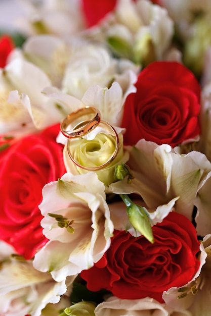 Gouden trouwringen aan een boeket bloemen voor de bruid