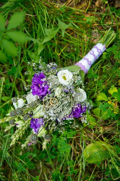 Gouden trouwringen close-up van bruiloft boeket